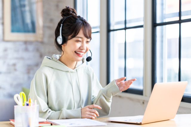000186_01_テレワークでウェブ会議をする若い女性