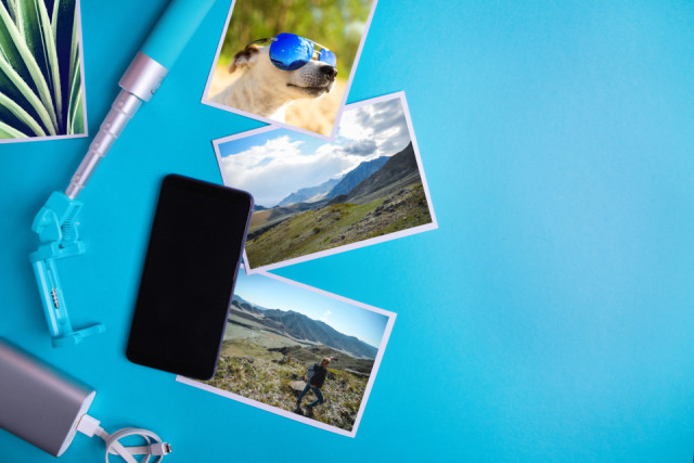 青い背景に空白の画面、チラシ、写真を持つスマートフォン