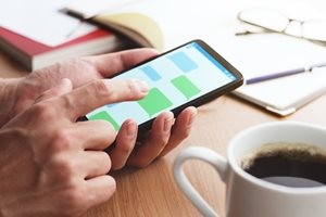 メッセージアプリを使う男性の手のアップ