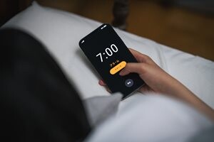 スマホのアラームを止める女性