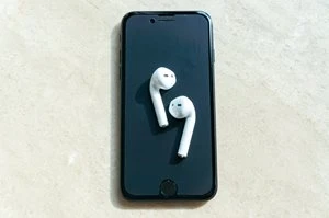 白いワイヤレスイヤホンとスマホ